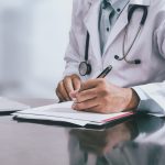 Medico che compila la certificazione per la riapertura infortunio INAIL e la riammissione in temporanea