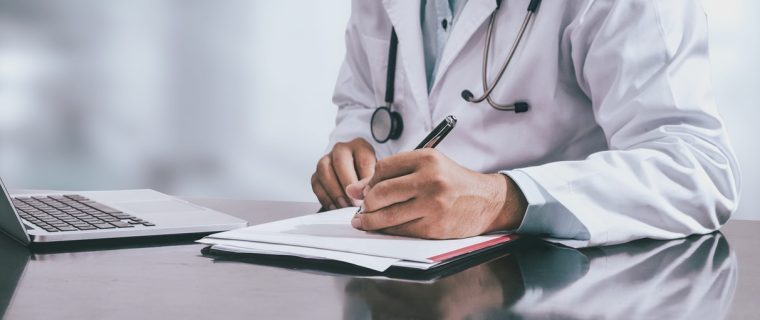 Medico che compila la certificazione per la riapertura infortunio INAIL e la riammissione in temporanea