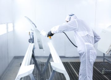 Operatore con dispositivi di protezione individuale che maneggia prodotti contenenti diisocianati secondo la normativa REACH