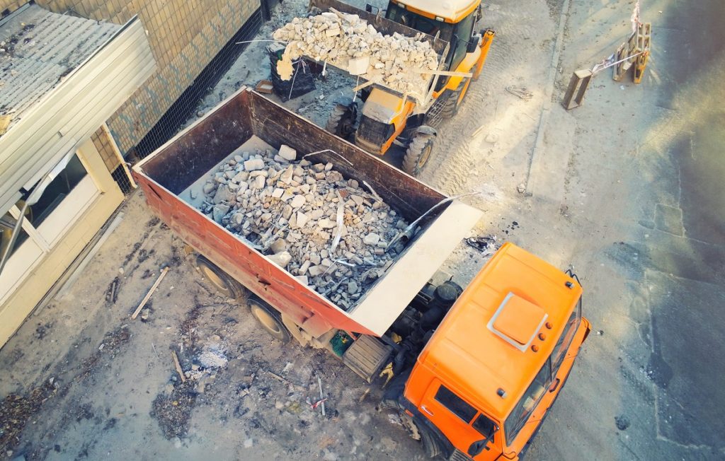 Camion che trasporta rifiuti inerti da costruzione e demolizione, come macerie e detriti edili.