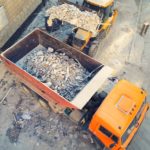 Camion che trasporta rifiuti inerti da costruzione e demolizione, come macerie e detriti edili.