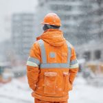 Lavoratore in cantiere durante l’inverno esposto a stress termico da freddo.