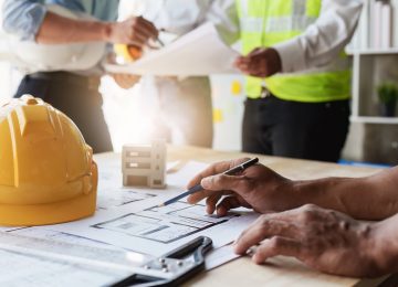 Professionisti edili al lavoro su planimetrie per adeguamento ai CAM Edilizia 2025