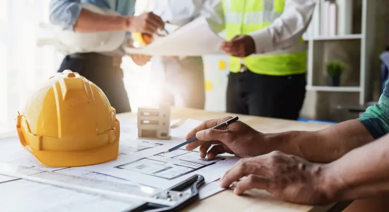 Professionisti edili al lavoro su planimetrie per adeguamento ai CAM Edilizia 2025