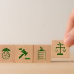 Illustrazione concettuale su cubi di legno delle novità ambientali nella Legge di Bilancio 2026: normativa, controlli e tutela del territorio.