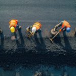 Operai edili esposti a raggi UV e gas di scarico diesel in cantiere.