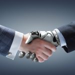 Stretta di mano tra un braccio robotico e una mano umana a simboleggiare la governance dell'IA e la cooperazione sostenibile tra tecnologia e lavoratori.