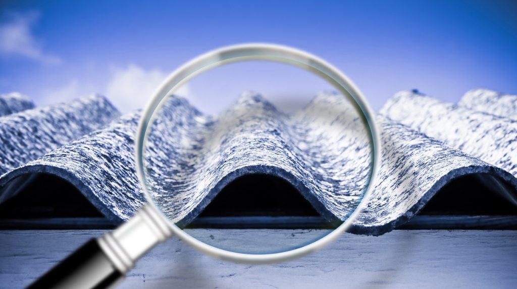 Particolare di una lastra in cemento-amianto analizzata attraverso una lente d'ingrandimento per evidenziarne le fibre pericolose.