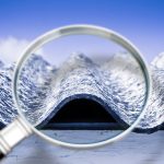 Particolare di una lastra in cemento-amianto analizzata attraverso una lente d'ingrandimento per evidenziarne le fibre pericolose.