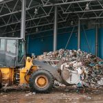 Gestione e rimozione di depositi di rifiuti storici con mezzi meccanici in area industriale.