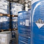 Imballaggi industriali contaminati da sostanze pericolose in area di stoccaggio