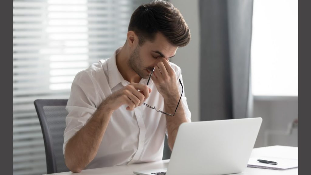 Lavoratore affaticato davanti al computer, rischio stress lavoro-correlato e salute mentale sul lavoro