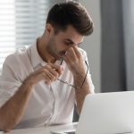 Lavoratore affaticato davanti al computer, rischio stress lavoro-correlato e salute mentale sul lavoro