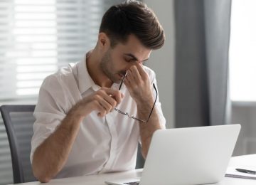 Lavoratore affaticato davanti al computer, rischio stress lavoro-correlato e salute mentale sul lavoro