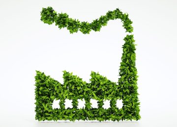 Icona di complesso industriale realizzata con foglie verdi per illustrare i criteri CSC in siti a uso misto.