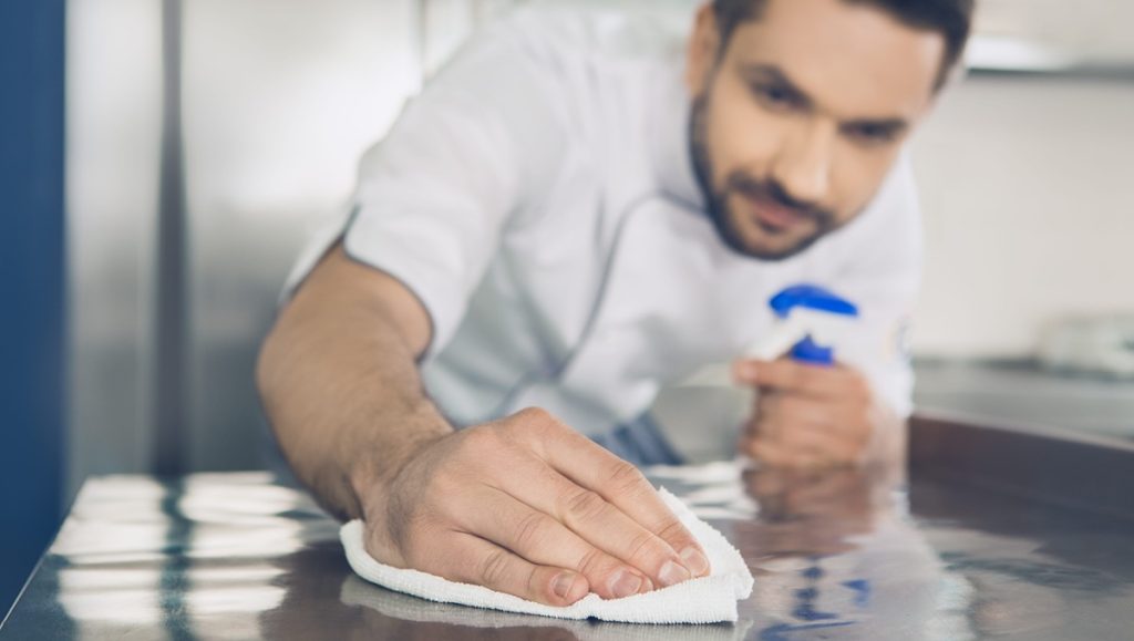 Operatore professionale utilizza detergenti conformi al Regolamento UE 2026 405 per la sanificazione ambientale.