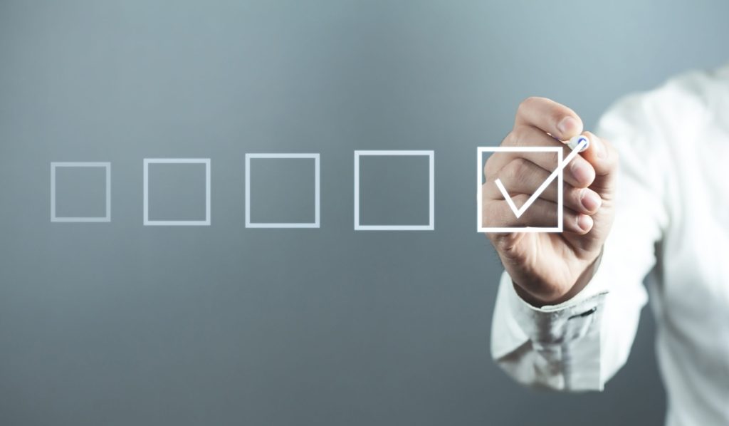 Primo piano di un consulente sicurezza in camicia bianca che appone un segno di spunta su una checklist virtuale, simboleggiante l'applicazione corretta delle FAQ dell'Accordo Stato-Regioni 2025.