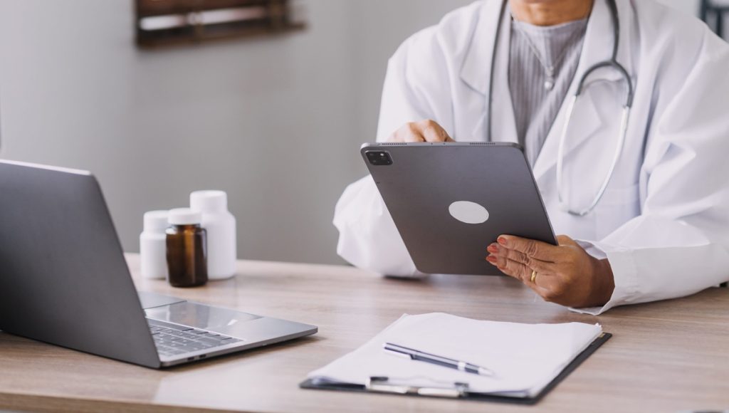 Medico che utilizza un tablet per la trasmissione telematica di un certificato di infortunio sul lavoro, ai sensi della Circolare INAIL 17/2026.